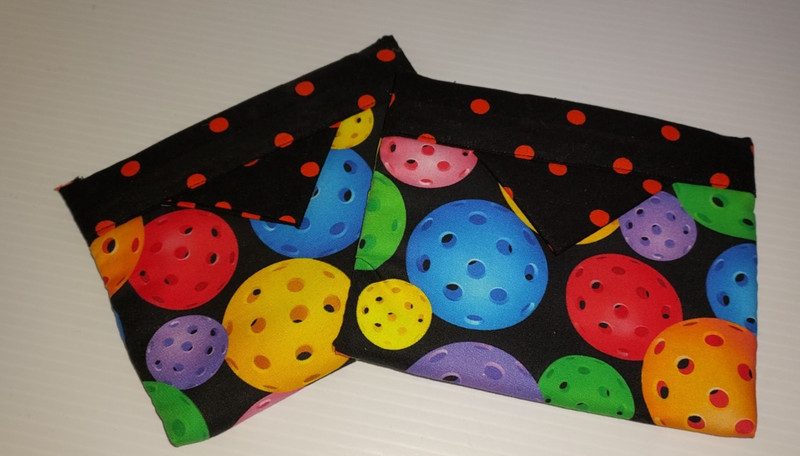 Snap purse with colorful pickle balls. Pull tabs to open, let go and snaps shut.