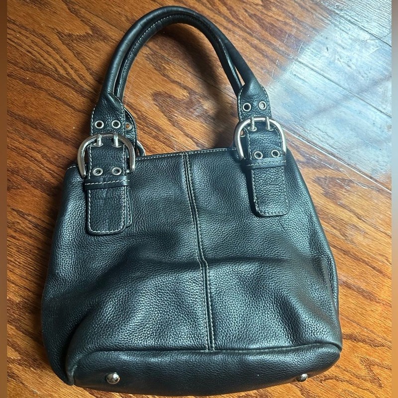 Tignanello bag prominent silver buckle hardware and contrast white stitching.